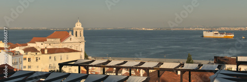 Church on Alfama and Tagus river during summer evening in Lisbon, Portugal