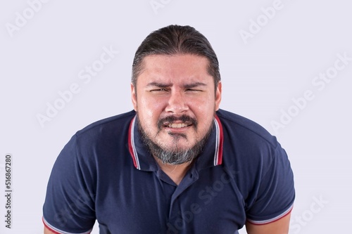 A middle aged man without glasses squinting and leaning forward in an attempt to focus clearly at something. Poor eyesight and nearsightedness to due to aging. Isolated on a white backdrop. photo