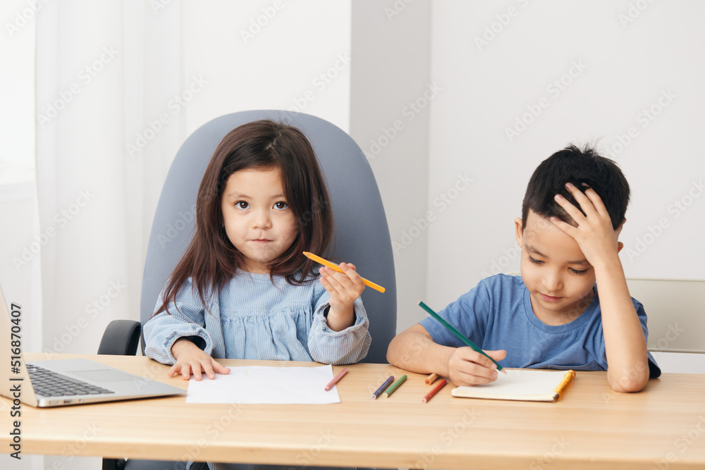cute little kids sitting drawing with pencils at the table during class cute little kids sitting drawing with pencils at the table during class