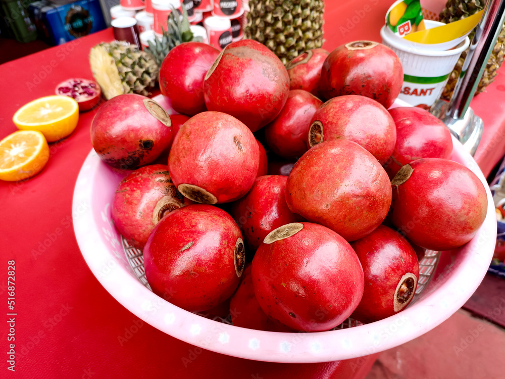 Red pomegranate fruits in basket on the table Red pomegranate fruits in basket on the table