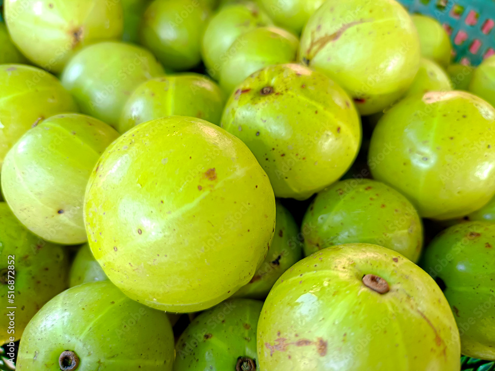 Indian gooseberry in the basket on a wooden floor Indian gooseberry in the basket on a wooden floor