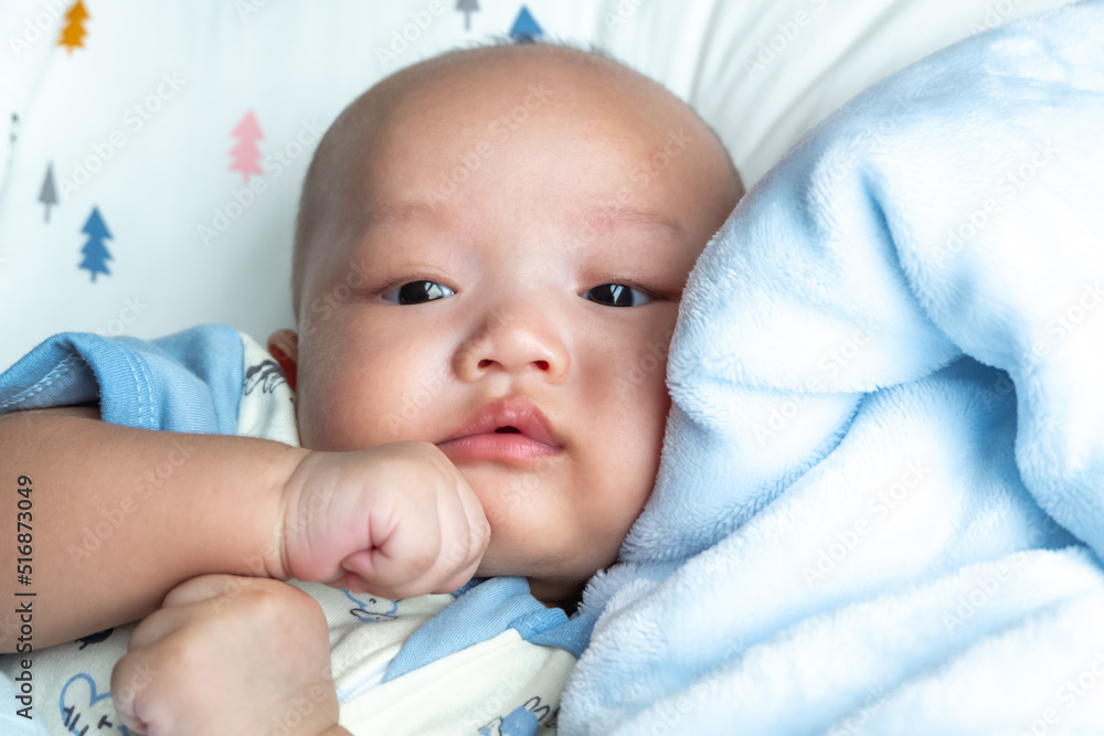 baby on chin, portrait on blue mattress baby on chin, portrait on blue mattress
