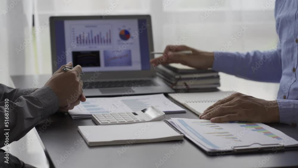 Statistical analysis of two business people on business data in a meeting graph on a laptop analyzing data. Two coworkers are overworked while brainstorming papers and graphs to present a 4k solution. Statistical analysis of two business people on business data in a meeting graph on a laptop analyzing data. Two coworkers are overworked while brainstorming papers and graphs to present a 4k solution.