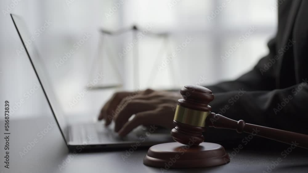 Prosecutor's office, laptop hammer in front of scales statue next to lawyers and legal tiger skins at online advisory concept desk. 4k video. Prosecutor's office, laptop hammer in front of scales statue next to lawyers and legal tiger skins at online advisory concept desk. 4k video.