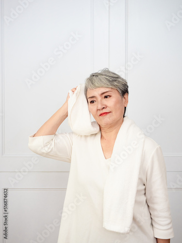 Portrait of mature aged asian woman 50s with towel at home.
