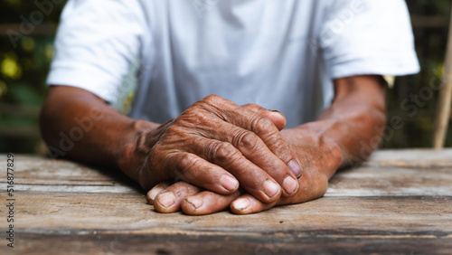 Billede på lærred Close up of male wrinkled hands, old man is wearing on the wood table