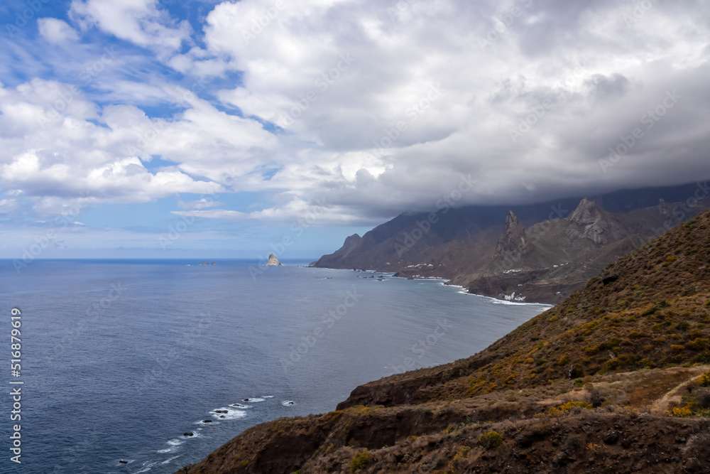 Scenic view of Atlantic Ocean coastline and Anaga mountain range on Tenerife, Canary Islands, Spain, Europe. Looking at Roque de las Animas crag and Roque en Medio. Hiking trail from Afur to Taganana