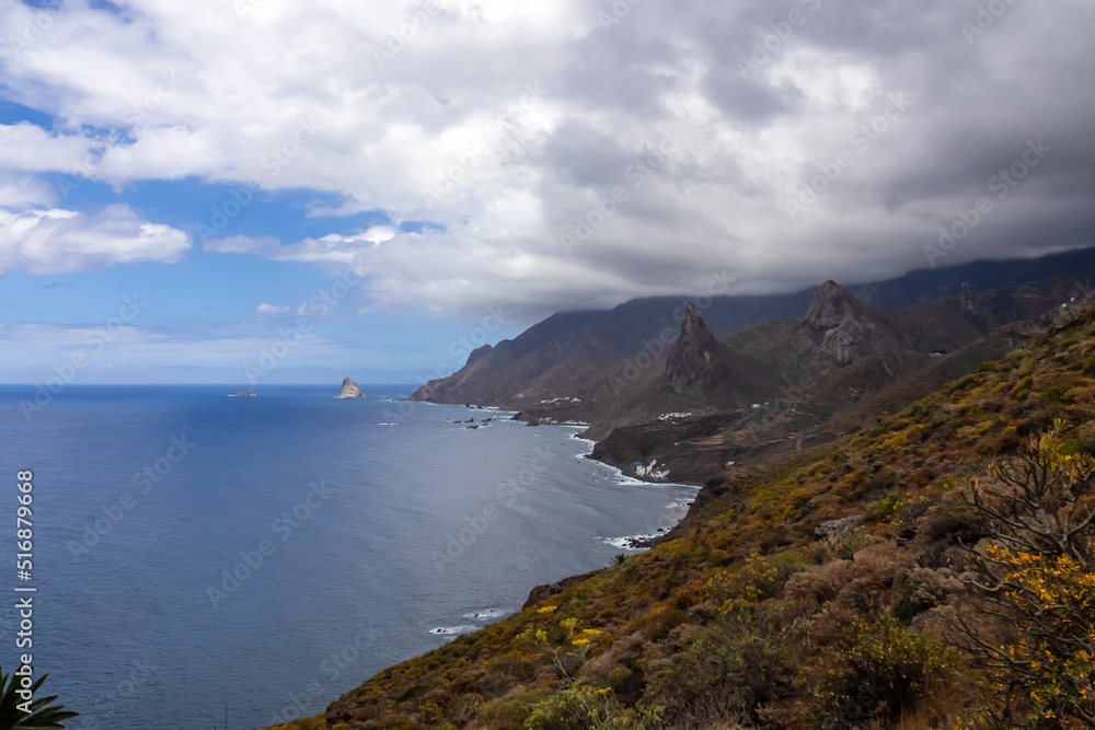Scenic view of Atlantic Ocean coastline and Anaga mountain range on Tenerife, Canary Islands, Spain, Europe. Looking at Roque de las Animas crag and Roque en Medio. Hiking trail from Afur to Taganana