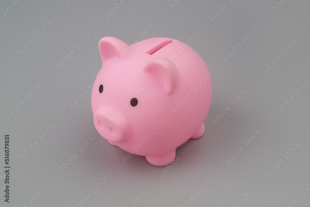 Pink piggy bank on grey background. Savings and investing concept.