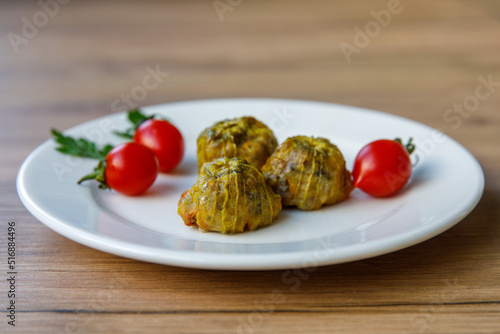 Traditional delicious Turkish - Greek cuisine, Turkish food Stuffed zucchini flowers (Turkish name kabak cicegi dolmasi) on white plate. Side view photo