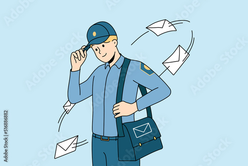 Smiling postman in uniform with bag full of post to deliver. Happy young mailman delivering letters to receivers. Postal service. Vector illustration.  photo