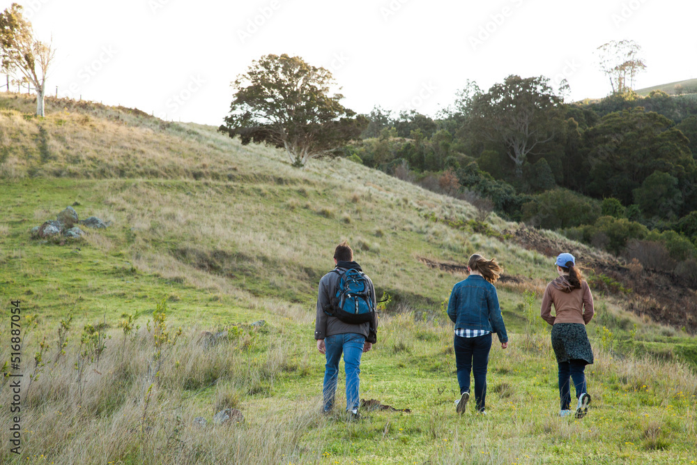 Three teens walking up a hill on a windy morning Three teens walking up a hill on a windy morning