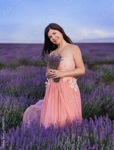 Beautiful girl on the lavender field. Beautiful woman in the lavender field on sunset.Beautiful healthy hair. Young teen girl brunette with long shiny hair over lavender field