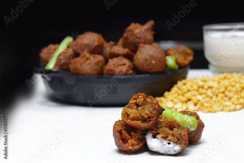 Delicious  crispy and crunchy Indian deepfried snacks Dal vada or dal pakoda or moong dal vade or pakora or fritters with green chilly and chutney or curd. photo