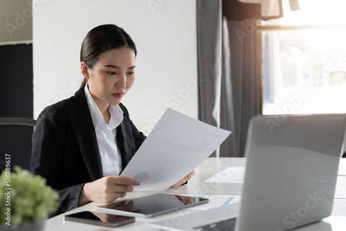 business woman or accountant working on calculator to calculate business data, accountancy document and laptop computer at office, business concept