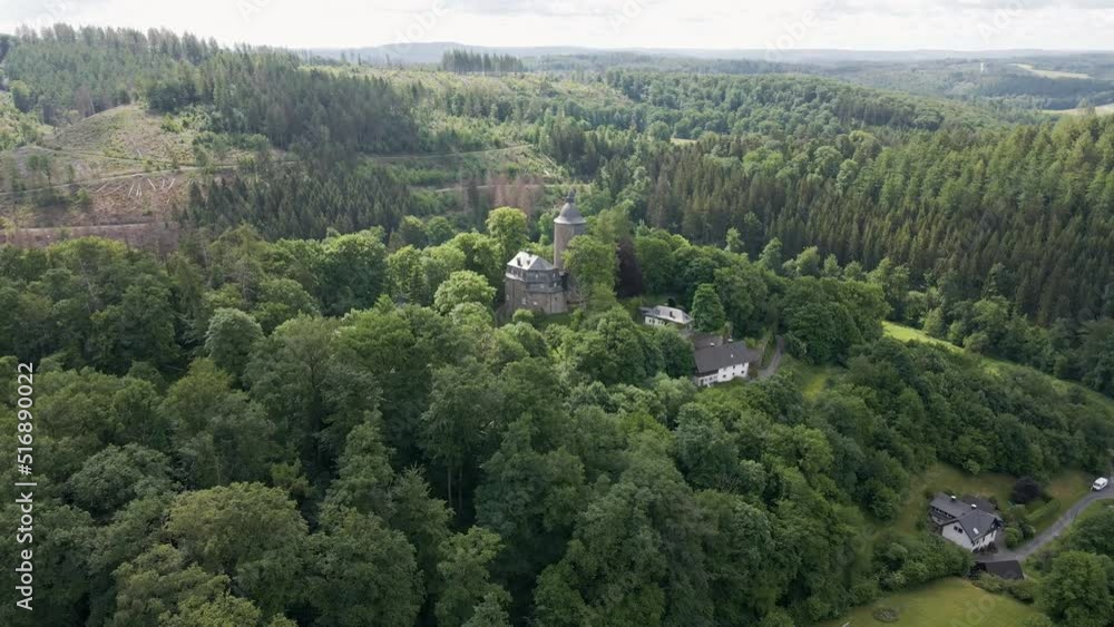 rearward drone shot of Wildenburg Castle in the southeast of the village of Friesenhagen in the North Rhine-Westphalia region of Germany. rearward drone shot of Wildenburg Castle in the southeast of the village of Friesenhagen in the North Rhine-Westphalia region of Germany.