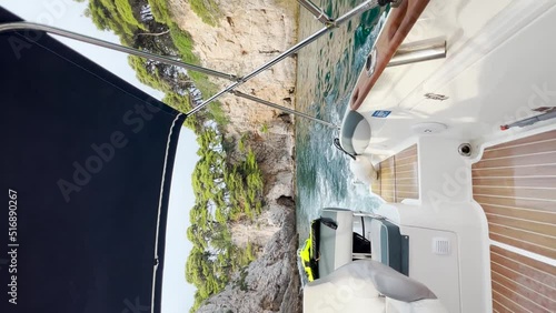 View from the stern of the boat going fast while leaving a trail of foam behind it. View of the rocky Kolocep Island ahead, Croatia. photo