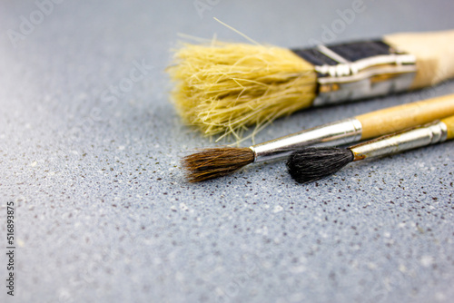Three brushes for painting close-up. Art brushes on a blue background.