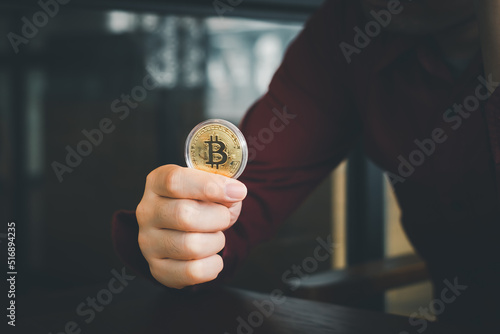 Bitcoin gold coin. Hand holding a gold coin bitcoin, cryptocurrency, btc crypto currency.
