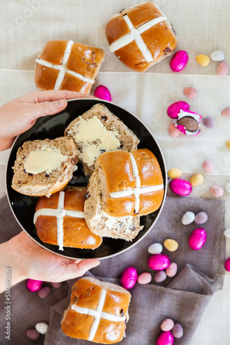 Buttered hot cross buns and scattered eggs at Easter on a plate photo