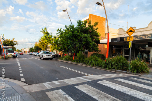 Car driving along small town road with speed hump pedestrian crossing