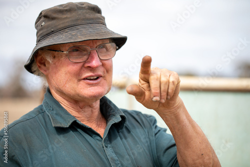 head and shoulders of older manual worker pointing index finger photo