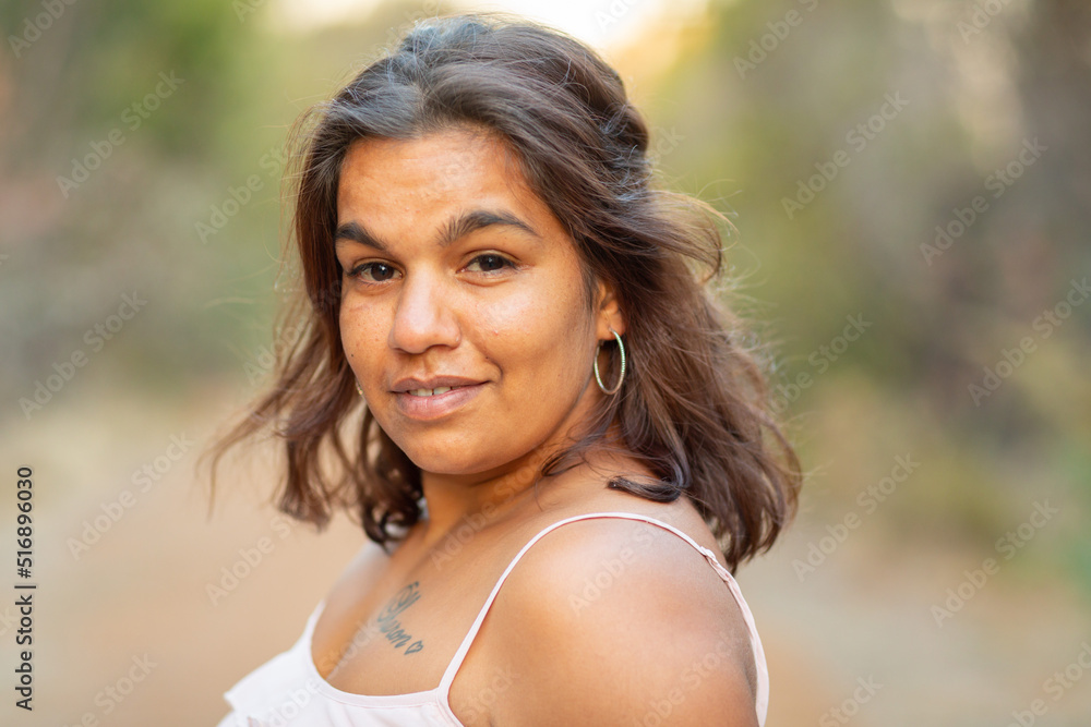 head and shoulders of young aboriginal woman outdoors with blurry background head and shoulders of young aboriginal woman outdoors with blurry background