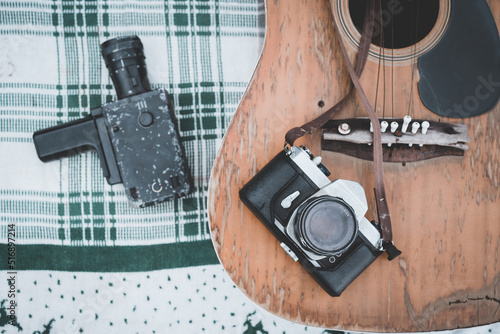 Old retro camera on vintage wooden guitar background.