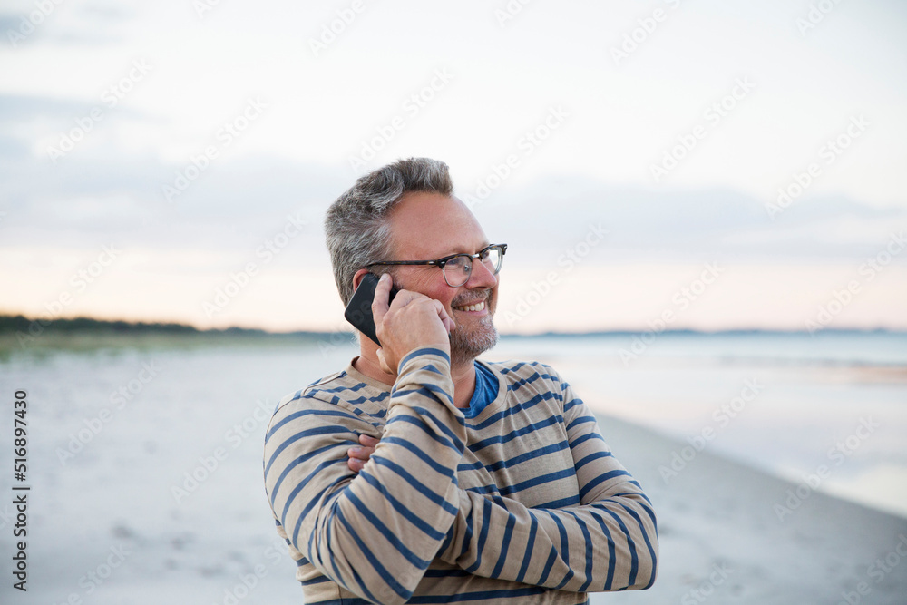 Man talking on smart phone at beach Man talking on smart phone at beach