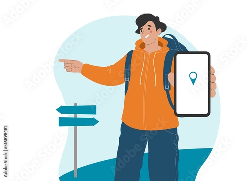 Cheerful male tourist points direction with his finger. In his other hand he holds smartphone, destination is displayed on screen.
