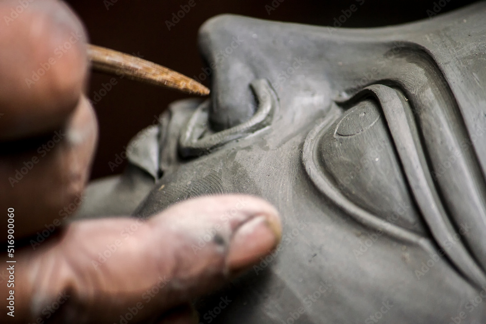 Creating clay head of goddess Durga in Kumartuli, Kolkata, India. The idols are made for the Hindu festival of Durga Puja also known as Dussehra