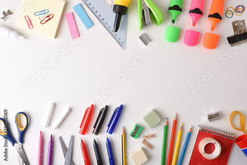 Assortment of colorful school supplies arranged on white table