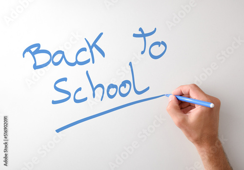 Hand writing back to school on white board
