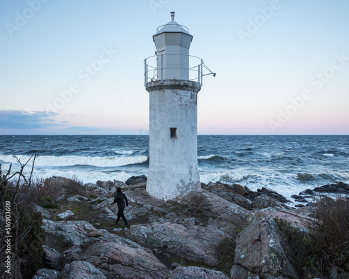 Young woman walking by lighthouse in Stenhuvud National Park Sweden photo