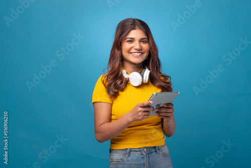 Beautiful happy young woman with headphones, coffee, phone , tablet, red cap 