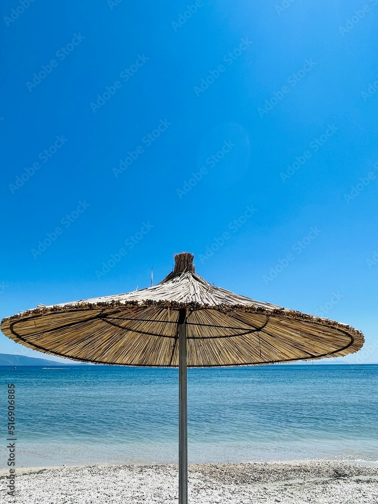 Straw beach umbrellas on a blue sky and sea background.Copy space 