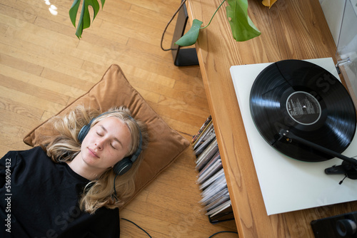 Teenage girl listening to music on record player photo
