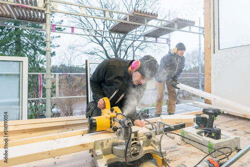 Carpenters cutting wood in house photo