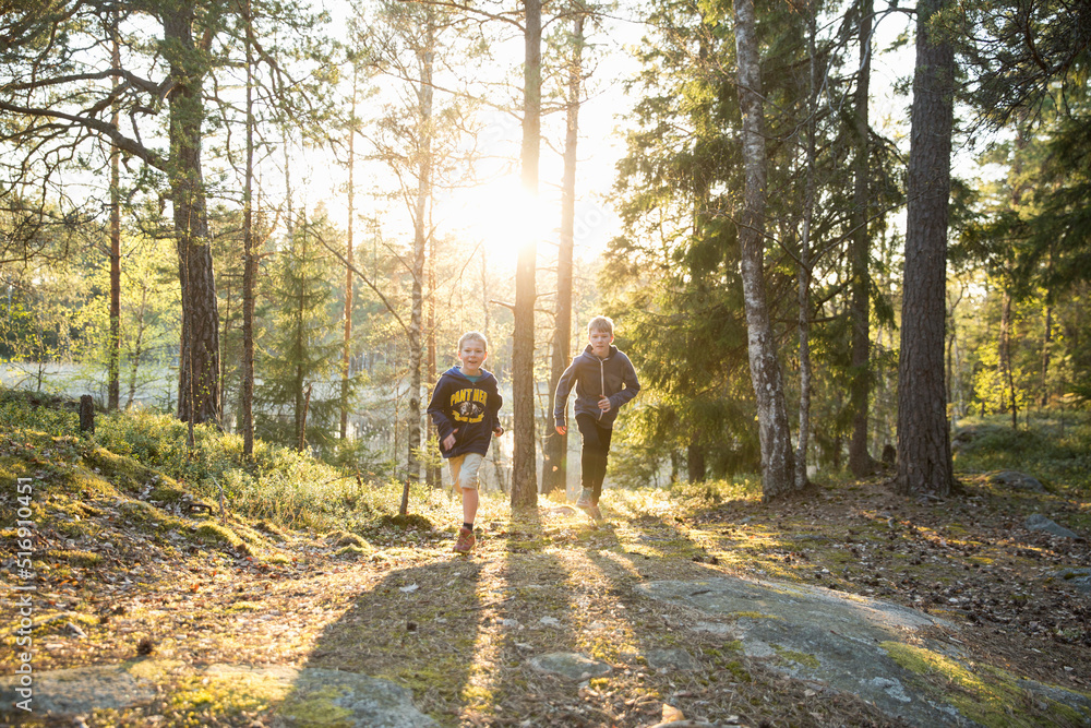 Brothers running in forest in Domarudden Nature Reserve Sweden Brothers running in forest in Domarudden Nature Reserve Sweden