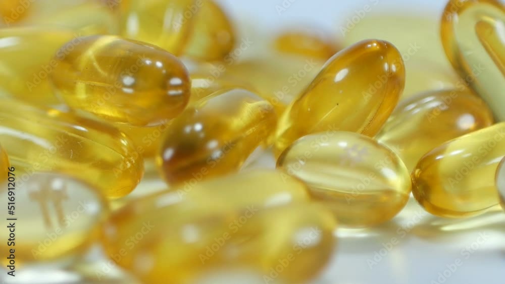 Close up slow motion many omega 3 or vitamin capsules rotate on a white background.Macro video. Close up slow motion many omega 3 or vitamin capsules rotate on a white background.Macro video.