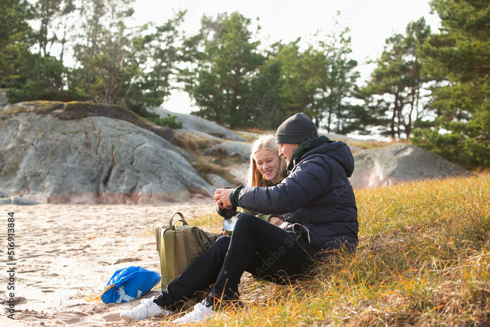 Father and daughter sitting in grass by beach Father and daughter sitting in grass by beach