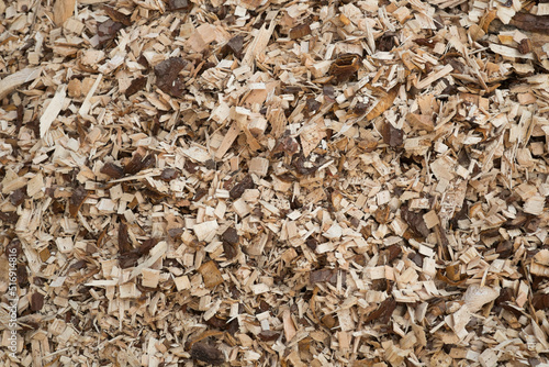 A pile of pine wood shavings with a blue sky in the background. Solid fuel for stoves from coniferous wood.