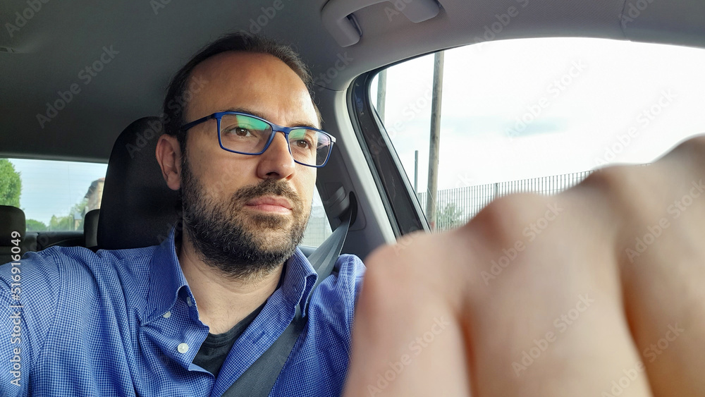 Uomo alla guida della propria automobile in città Uomo alla guida della propria automobile in città