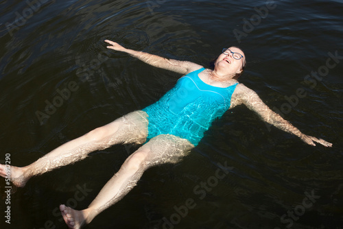 Mature woman swimming in lake photo