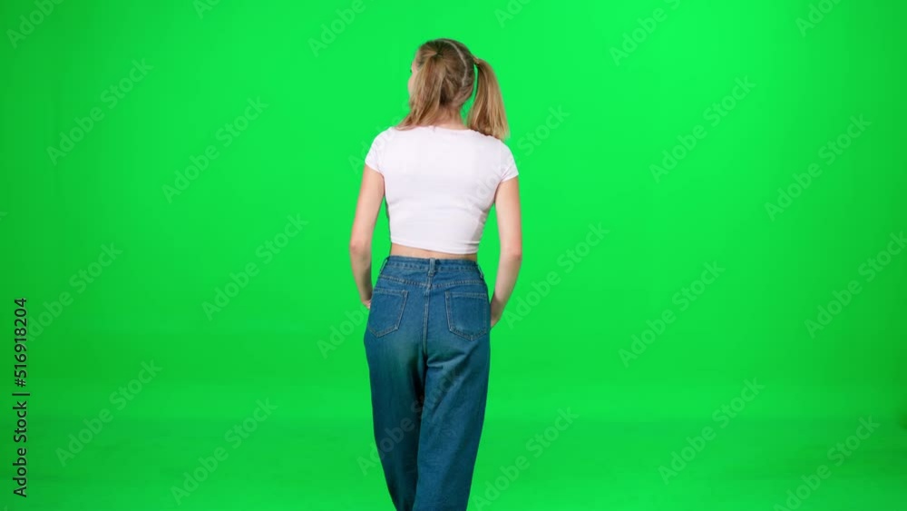 Young female walking down the street on a green background, a passerby on a walk, chroma key template, a girl in a white t-shirt and blue jeans, back view. Young female walking down the street on a green background, a passerby on a walk, chroma key template, a girl in a white t-shirt and blue jeans, back view.