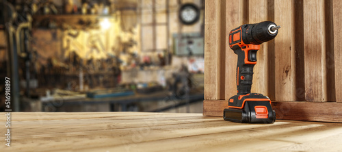 Foto Black and orange drill and workshop interior.