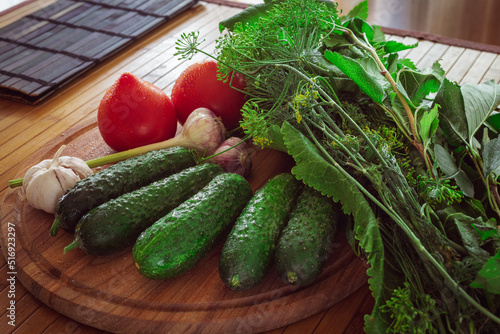 Fresh vegetables on a wooden table. Greens and dill for pickling vegetables.