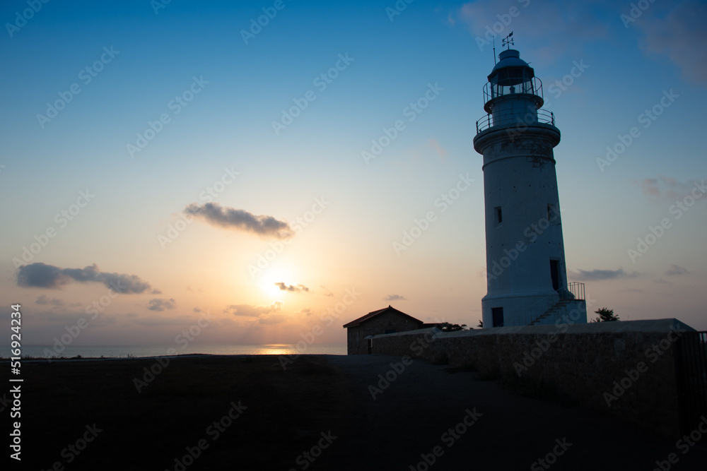Beautiful sunset on coastline of Kato Paphos. The lighthouse in ancient complex park Kato Paphos.