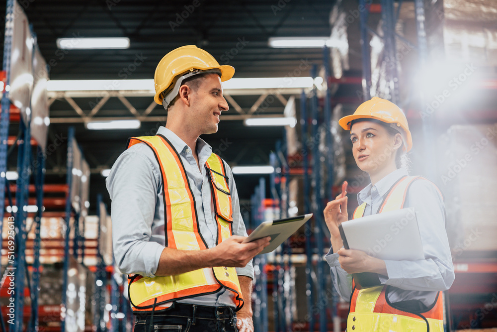 Caucasian male staff worker in cargo warehouse manager talking work with lady teamworking industry. Caucasian male staff worker in cargo warehouse manager talking work with lady teamworking industry.