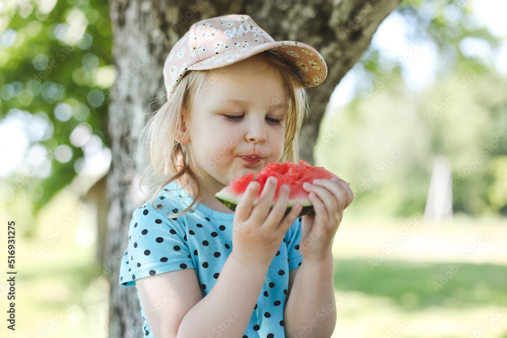 cute little girl eating watermelon outdoors in summertime. Child and watermelon in summer. cute little girl eating watermelon outdoors in summertime. Child and watermelon in summer.